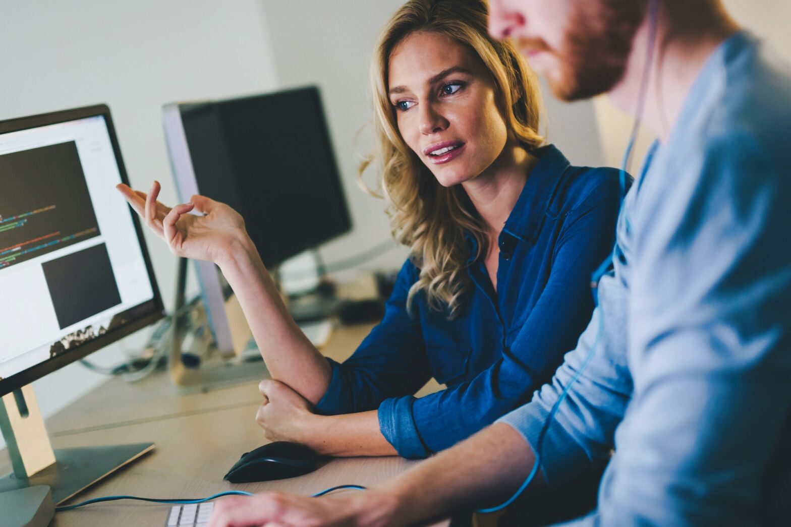 A woman pointing on a monitor